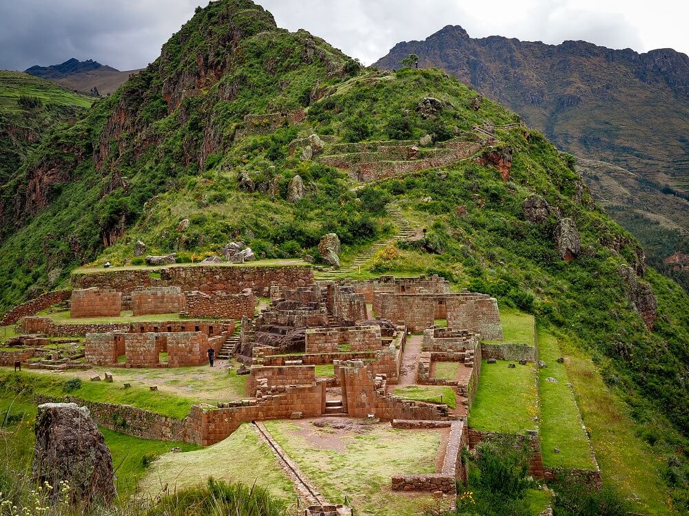 An image of old Inca ruins with mountains behind it in the Cusco region of Peru