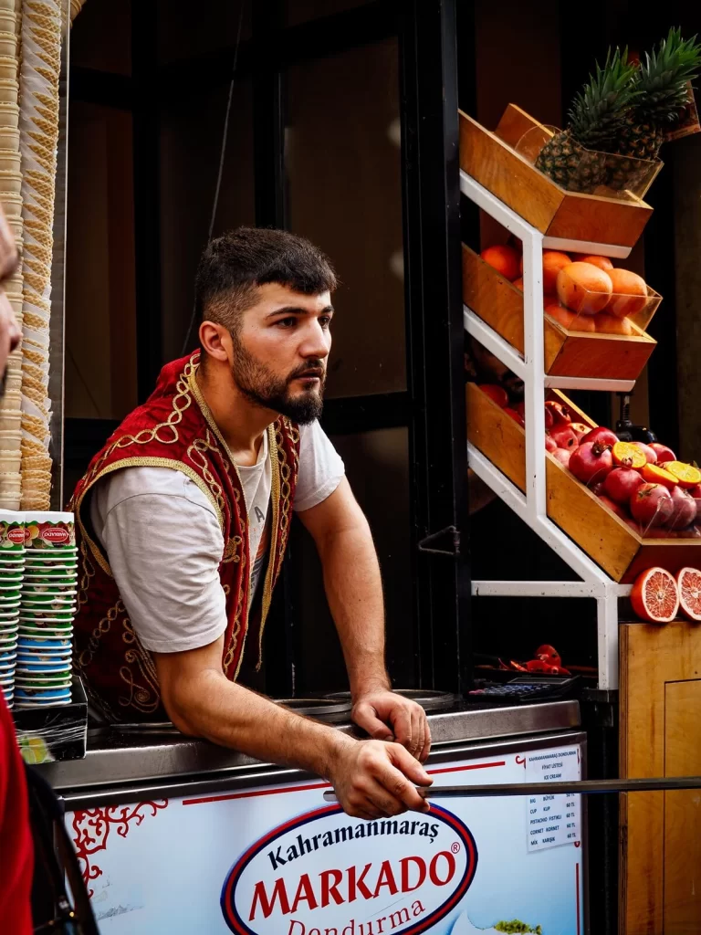 A male wearing a traditional Turkish vest in an ice-cream booth 