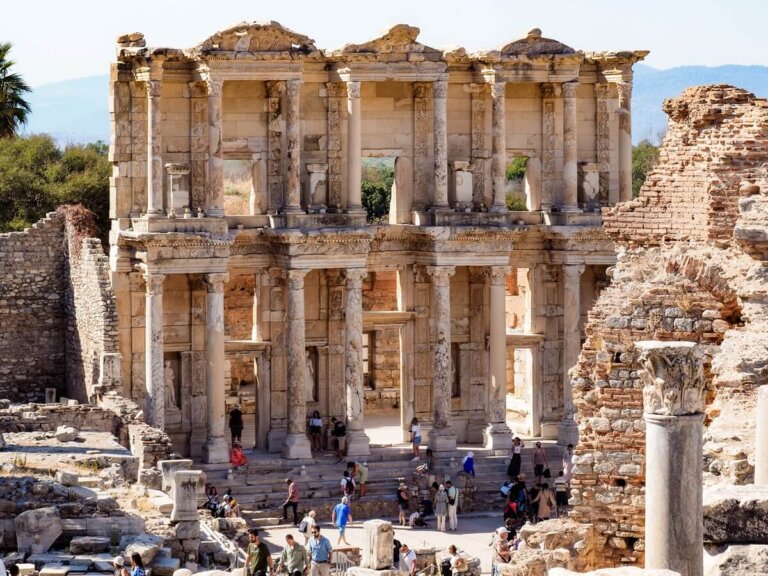 An ancient historical structure in Ephesus Turkey with tourists in front of it