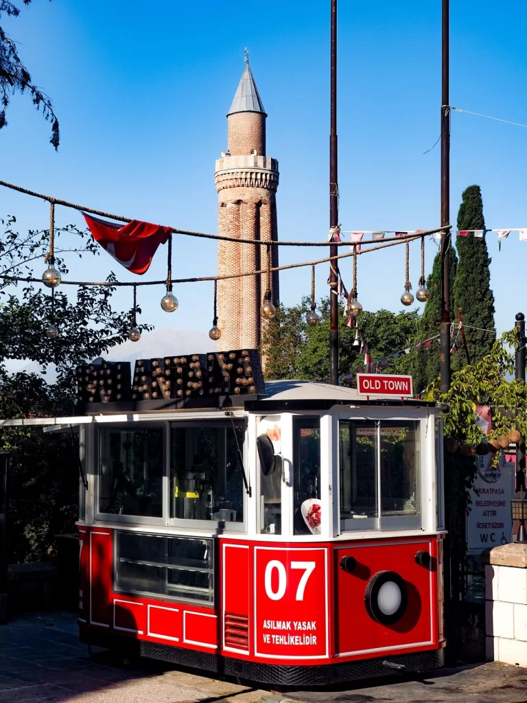 A red and white vintage tram with a minaret in the background