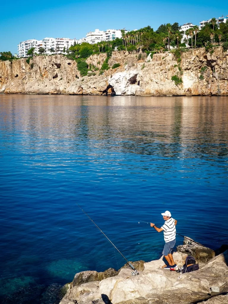 A fisherman is fishing in the harbour 