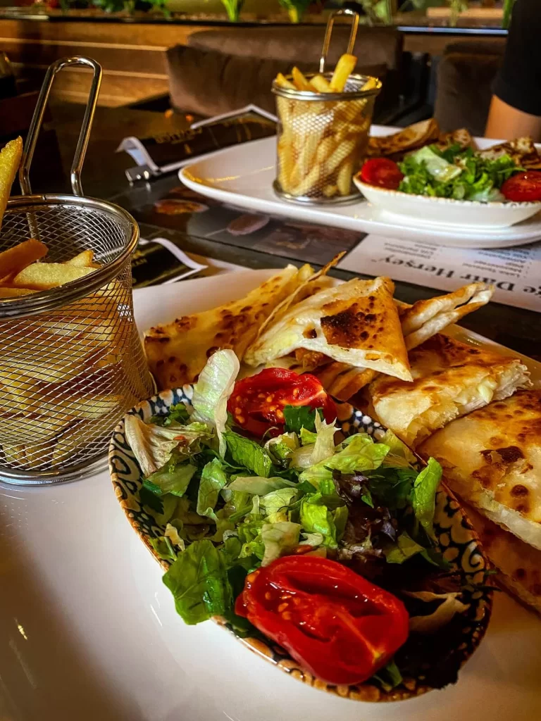 a plate of salad, fries and a Turkish dish called gozleme