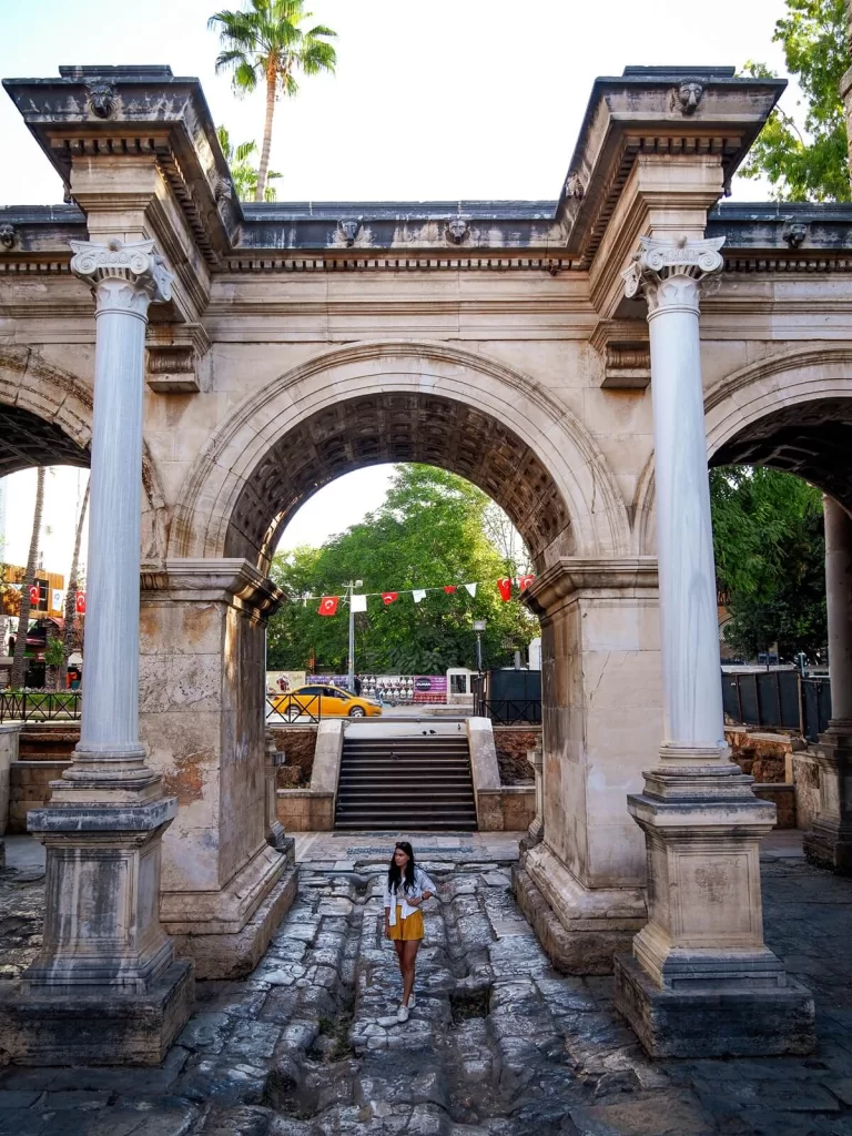 A female traveller is walking through the arch of a Roman Gate in Kaleici Antalya