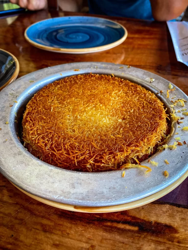 A shallow plate of Traditional Turkish dessert called Kunefe on a table