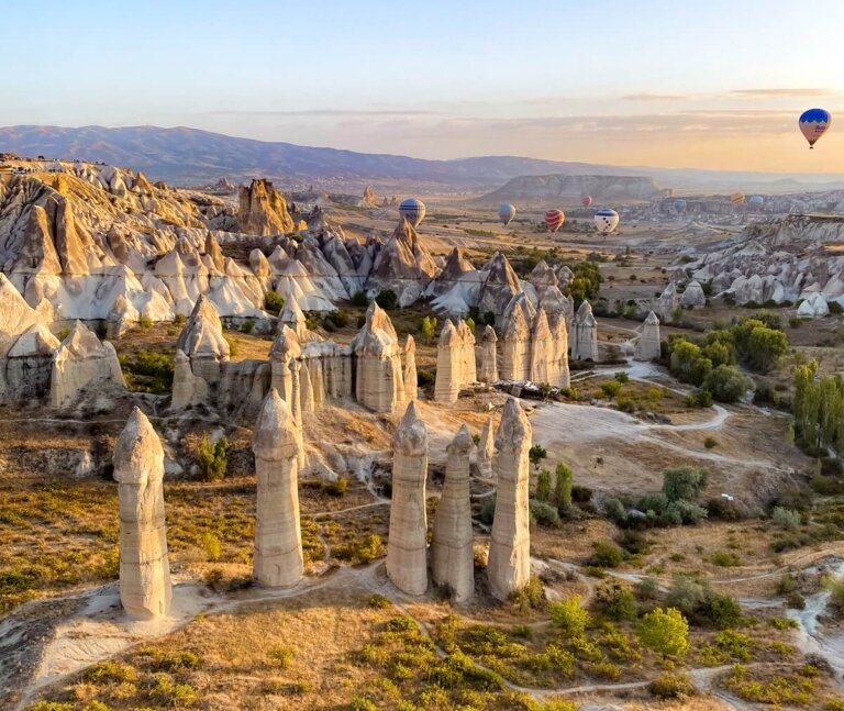 View of a valley with tall rock formations (Fairy Chimneys) in Cappadocia