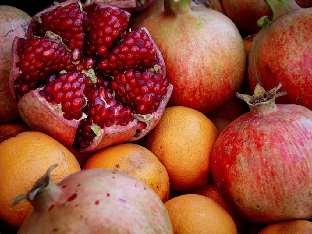 a selection of pomegranate fruit with one cut in half