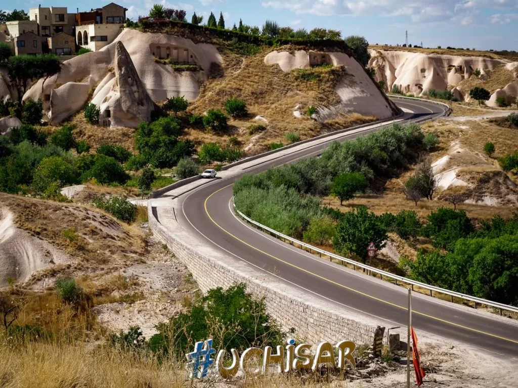 A main road surrounded by rock formations in a small town in Cappadocia
