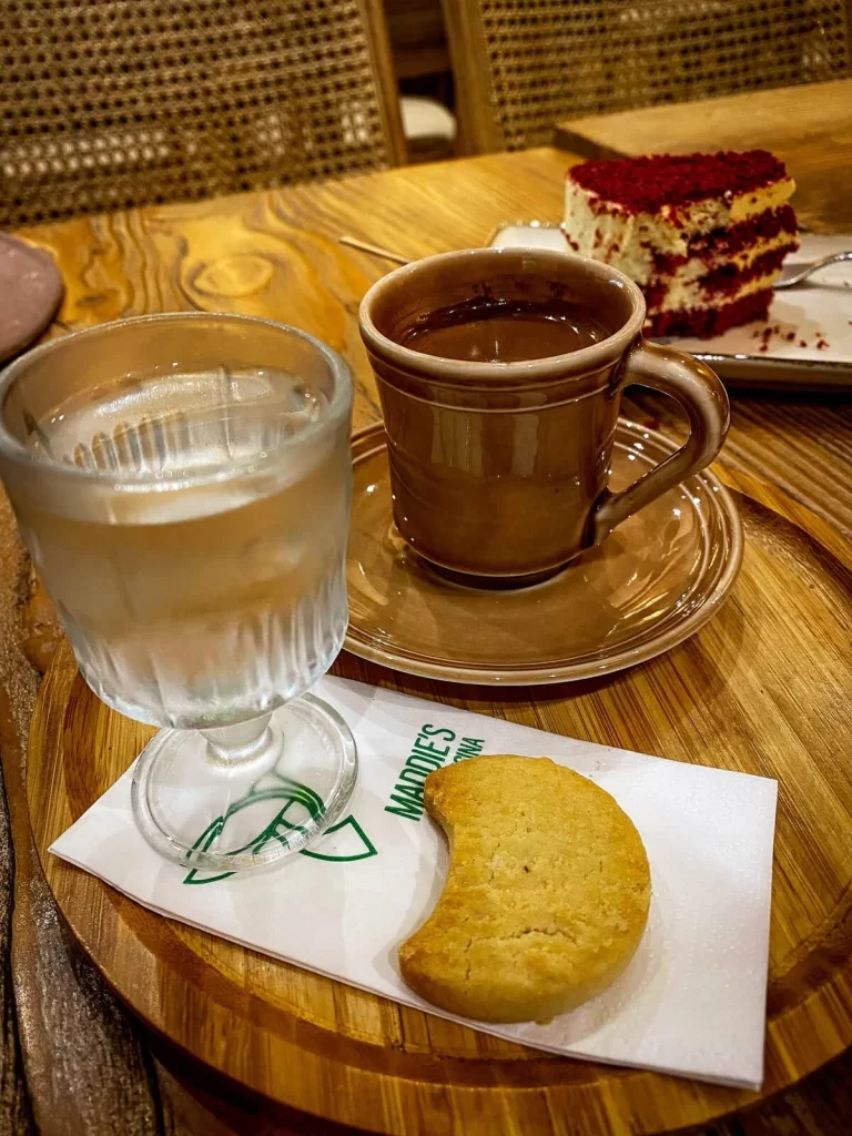 Traditional Turkish Coffee served with a glass of water and a small biscuit