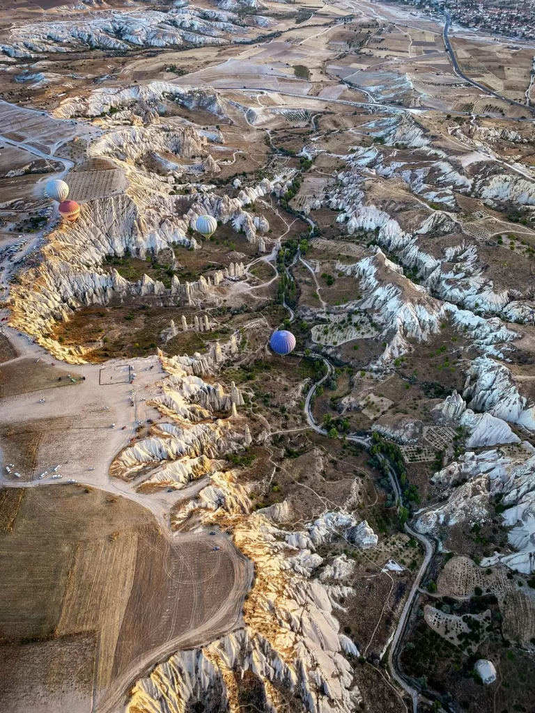 Hot air balloons flying in a valley with rock formation in Capapdocia