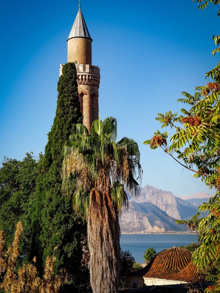 A minaret with trees in front of it in Antalya Turkey