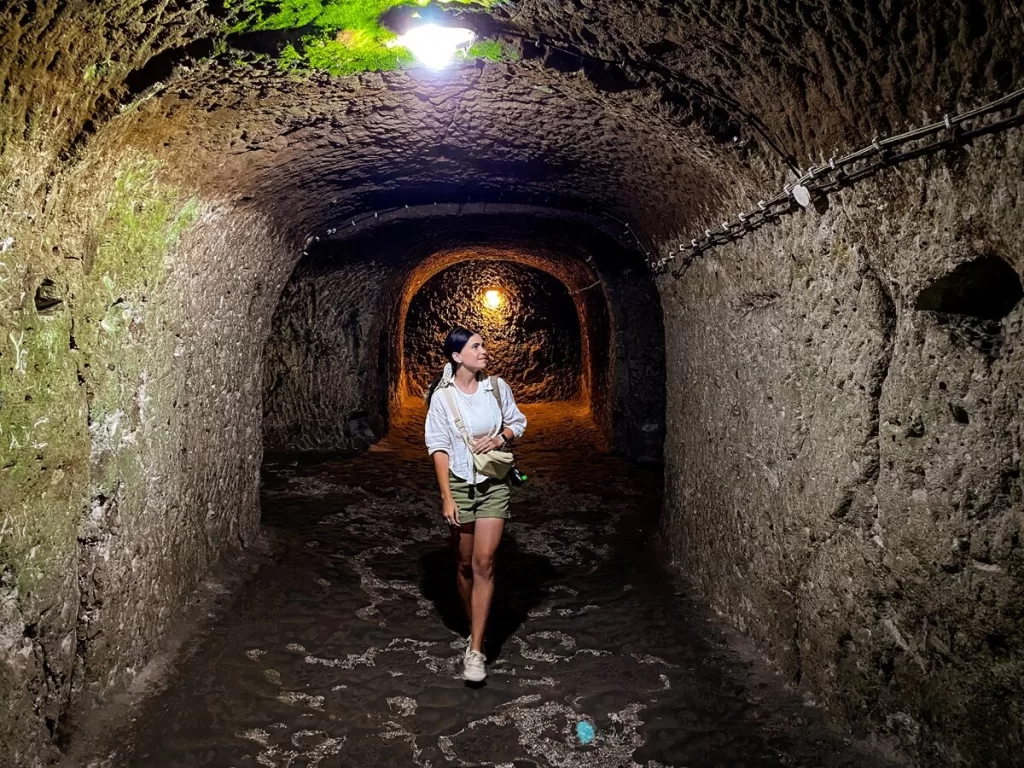 Female traveller is walking in a tunnel of an underground city of Cappadocia