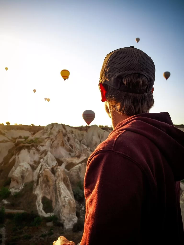 Male traveller is looking at hot air balloons