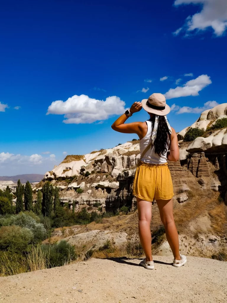 Female Traveller wearing a hat is looking out to a valley in Cappadocia Turkey