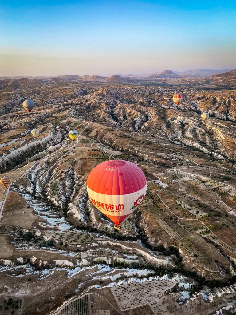 View of a hot air balloon and the valleys of Cappadocia