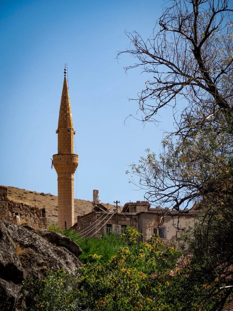 A minaret of a mosque in a green valley in Cappadocia