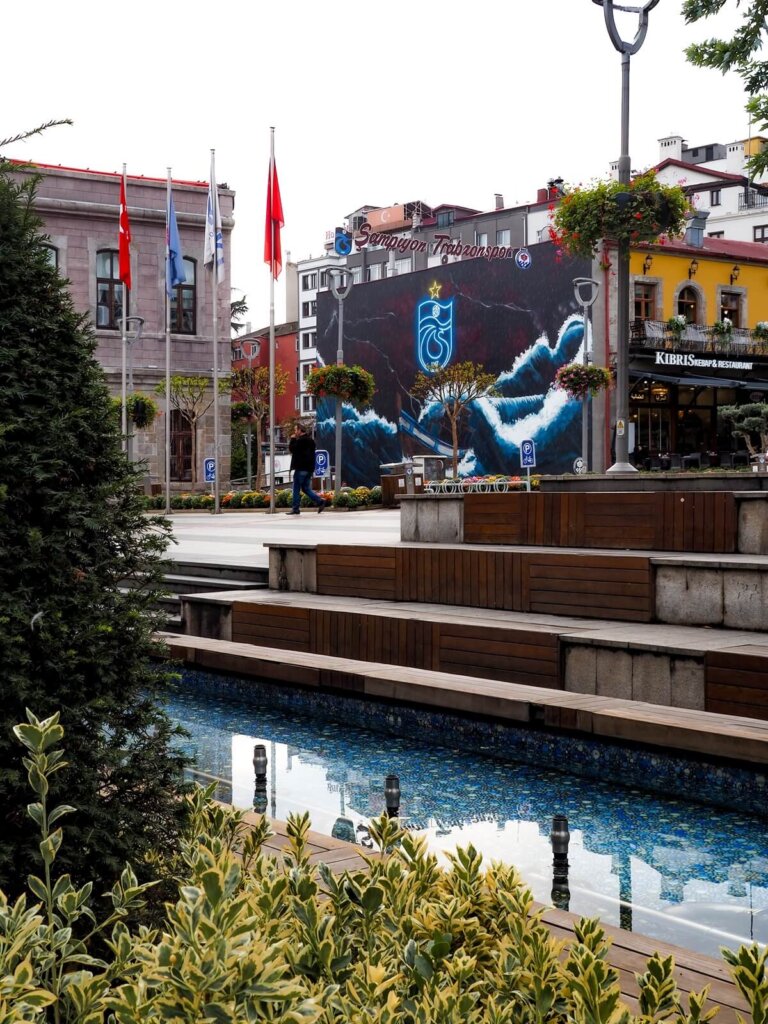 a main square with buildings, a fountain and some greenery in Trabzon Turkey