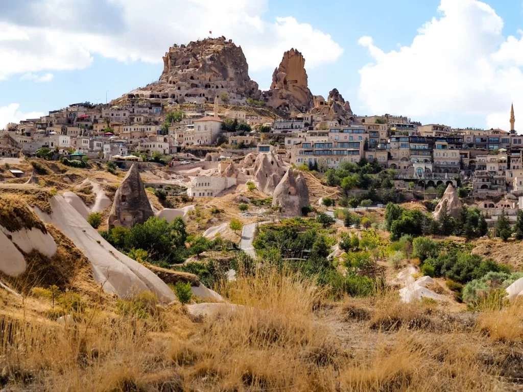 A small village with a huge rock-cut castle at the top in Cappadocia Turkey