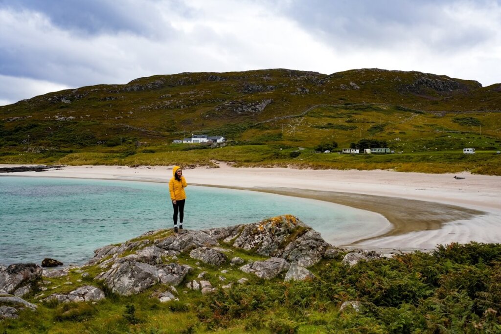 Girl is standing in front of Mellon Udrigle Beach in Scotland