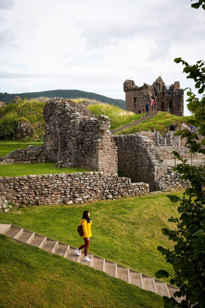 A female is walking down some stairs at Urquhart castle near Inverness Scotland