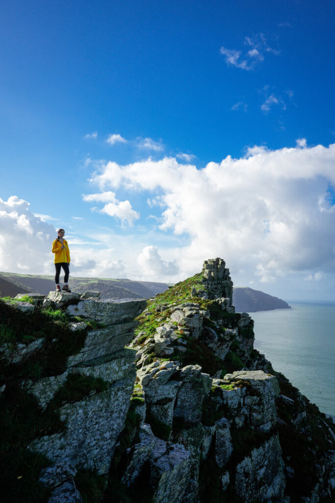 Hiker is standing on top of the cliff overlooking the Bristol Channel in Exmoor National Park