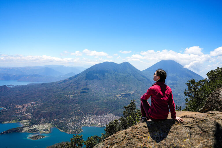 Hiker is sitting on a rock on top of Volcan San Pedro on Lake Atitlan