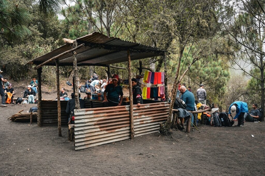 People are sitting around a shed along the Acatenango hiking trail