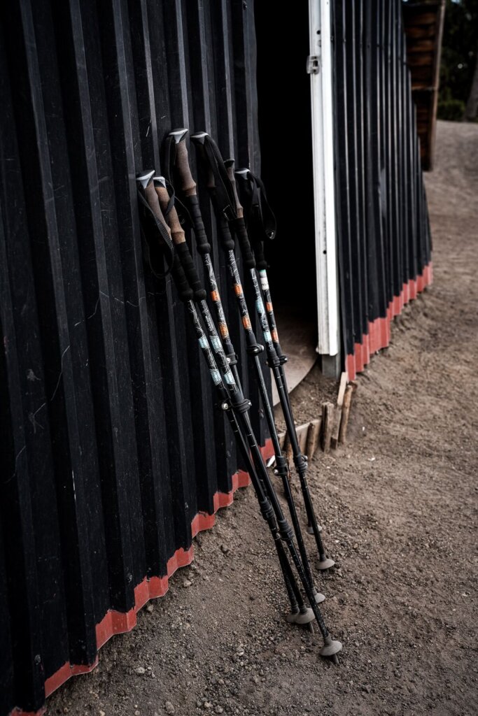 Hiking poles are leaning against a cabin wall