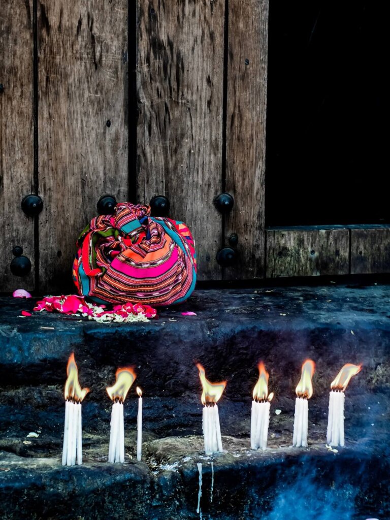 Lit candles in front of a church entrance in Guatemala