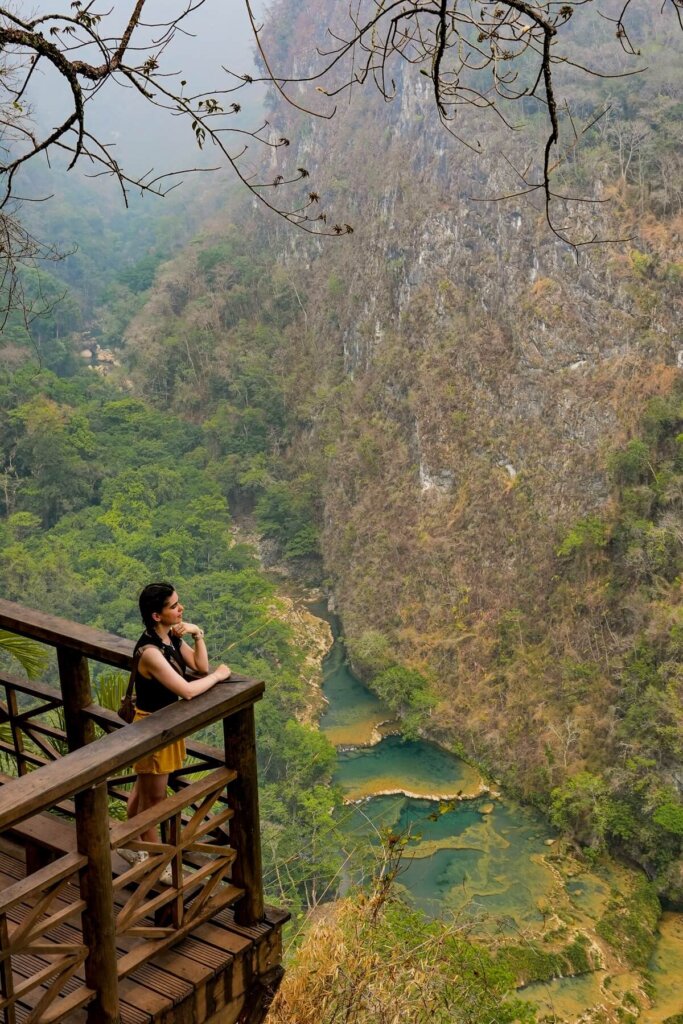 Female is standing at the viewpoint platform overlooking Semuc Champey in Guatemala