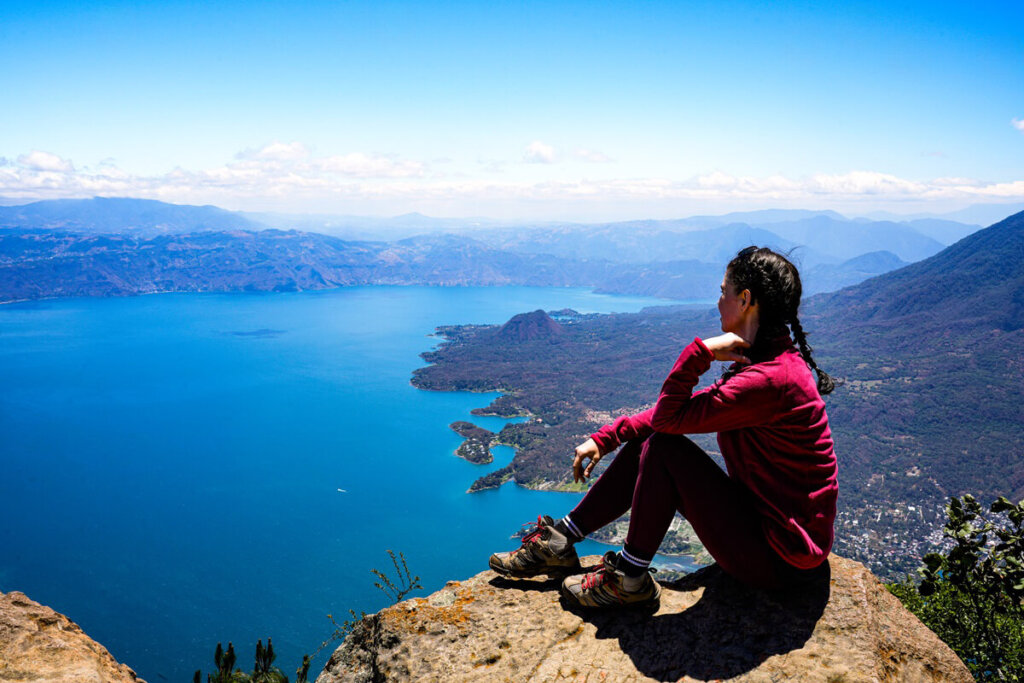 Hiker is sitting on a rock at the summit of San Pedro Volcano