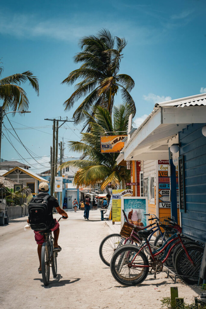 A person cycling along the street in Caye Caulker