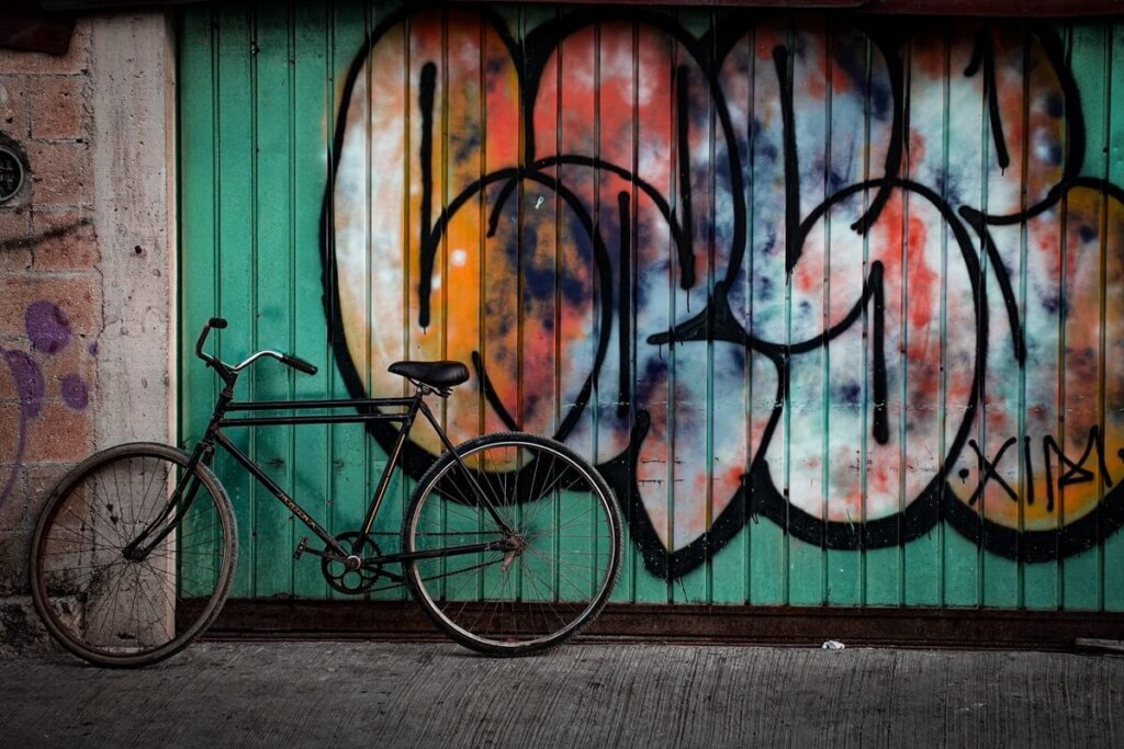 old bike in front of a graffiti wall